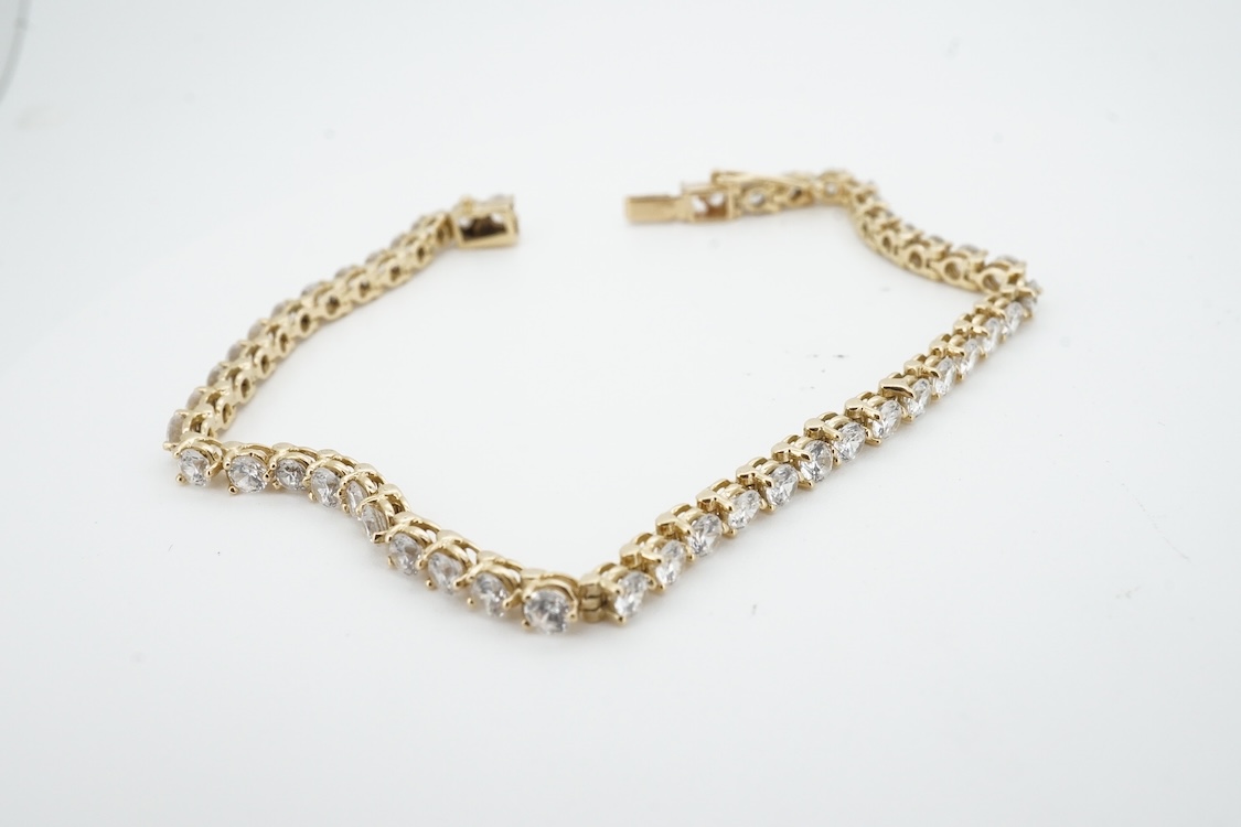 A modern yellow metal (stamped 585) and cubic zirconia set line bracelet, 18cm and a pair of similar drop earrings, together with a similar 9k and cubic zirconia set cluster ring, size N.
